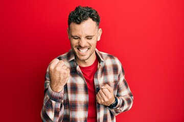 Young hispanic man wearing casual clothes celebrating surprised and amazed for success with arms raised and eyes closed