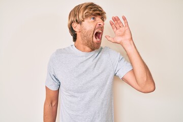 Sticker - Young blond man wearing casual clothes shouting and screaming loud to side with hand on mouth. communication concept.