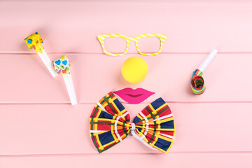 Wall Mural - Flat lay composition with clown's items on pink wooden table