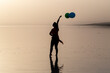 © FATIR29 - motivation or hope concept, follow your dream and inspiration, girl with balloons at sunset with sea
