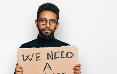 Poster - Young african american man holding we need a change banner thinking attitude and sober expression looking self confident