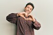 © Krakenimages.com - Handsome hispanic man wearing casual clothes smiling in love doing heart symbol shape with hands. romantic concept.