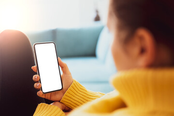 Wall Mural - woman using smartphone frameless mockup blank screen in home interior. working from home concept - v