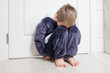 © oksix - the upset kid is sitting on the floor in a closed position