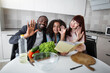 © sofiko14 - Cooking together, healthy food, family day concept. African father, Caucasian mom and cute teen mixed race daughter, sitting in the kitchen, looking at the camera with pleasure smiles