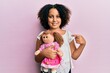 Young little girl with afro hair holding animal doll toy smiling happy pointing with hand and finger