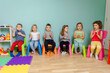 © oksix - Kids are sitting on the colorful chairs, clapping hand