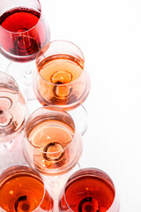  Rose wine glasses set on wine tasting. Degustation different varieties, colors and shades of pink wine concept. White background, top view