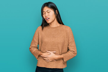 Sticker - Beautiful young asian woman wearing casual winter sweater with hand on stomach because nausea, painful disease feeling unwell. ache concept.