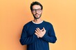 © Krakenimages.com - Young hispanic man wearing casual clothes and glasses smiling with hands on chest with closed eyes and grateful gesture on face. health concept.