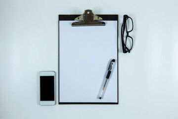 Clipboard and smartphone on white background.