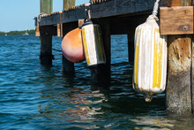 Boat Fenders Hanging On The Side Of A Wooden Dock