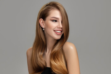 Young beautiful woman with a happy smile and long shiny hair. Perfect hairstyle and makeup