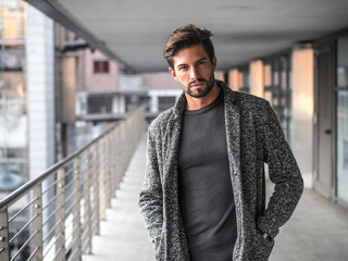 One attractive man in urban environment in city, walking, wearing cardigan