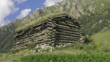 Mountain Scene With Shiel. An Ancient Wooden Shepherd's Hut With An Sod Roof In The Alpine Pastures. The Spirit Of Mountais And Hoary Antiquity
