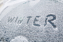 Word Winter Handwritten On Snowy Car Window At Winter Morning Light