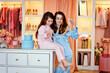 Happy family. Mother and daughter in blue and pink silk pajamas in the dressing room are having fun choosing pearl beads.