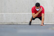 © Teran - Mexican man doing push ups outdoors wearing a white face mask