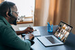 Business brainstorm, online video meeting, virtual conference with multiracial colleagues. African American man communicate with business partners by video call uses laptop and app, work from home