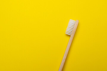 Bamboo brush on a yellow background. No plastic. Ecology. Taking care of the world around you. Toothbrush. Clean teeth. Yellow background. Copy space. of the environment.