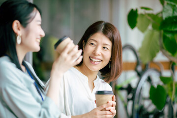 Poster - ホットドリンクを飲んでおしゃべりする女性
