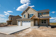 Two similar new construction homes sit side my side in a new housing development in Spokane County, Washington, USA.