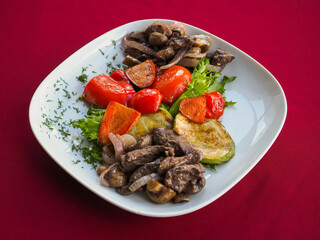 Beefsteak with tomato and herbs on a red background