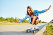 © baranq - Happy young woman riding longboard during sunny summer day