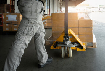 Wall Mural - Worker working with hand pallet jack unloading cargo boxes at storage warehouse. shipment boxes.	 