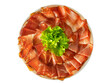 Plate of prosciutto speck ham with a salad leaf, plate of sliced smoked ham top view isolated on white background