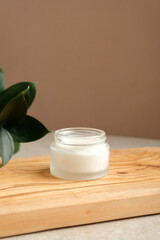 Wall Mural - jar of organic moisturizer cream with green leaves on wooden board. natural organic skincare product