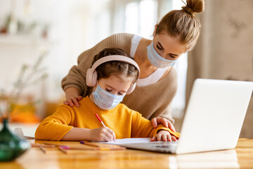 Wall Mural - Mother and kid in protective masks with laptop doing homework together