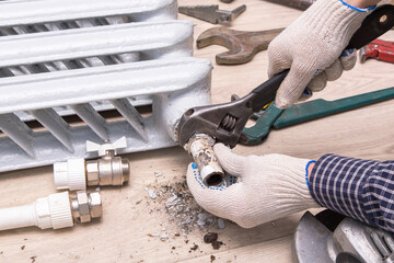 Plumber hands repairing valve radiator with spanner