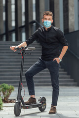 Wall Mural - Young man riding electric scooter in medical mask in face