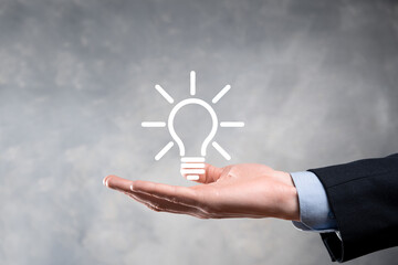 Businessman in a suit with a light bulb in his hands. Holds a glowing idea icon in his hand. With a place for text