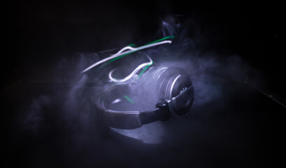 Wall Mural - Dj music club concept. Close up headphones on dark background with colorful light.