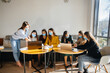 © Andrii - A group of girls in masks sit in a cafe and work on laptops. Teaching students.