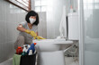 woman wearing mask wearing gloves brushing dirty toilet in bathroom