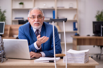 Wall Mural - Old businessman employee after accident working in the office