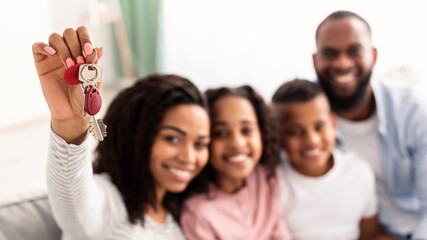 Happy African American family showing keys of their new apartment