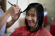 © Odua Images - Beautiful young woman getting her haircut by a hairstylist at a salon