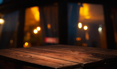 Empty wood table top on blurred light gold bokeh of cafe restaurant on dark background