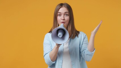 Wall Mural - Shocked crazy blonde young woman 20s years old in casual blue shirt posing isolated on yellow color background studio. People sincere emotions lifestyle concept. Screaming in megaphone spreading hands