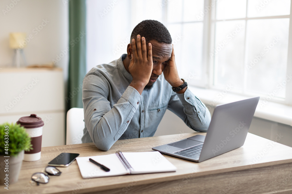 African Businessman At Laptop Touching Head Having Problem At Workplace