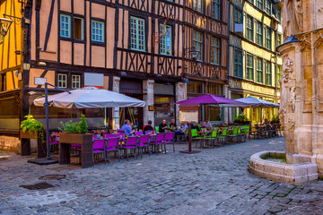 Cozy street with timber framing houses and tables of restaurant in Rouen, Normandy, France