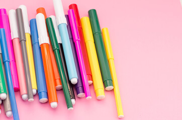 Canvas Print - Closeup shot of colorful markers on a pink background