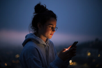 beautiful young woman use smartphone at night. millennial generation z female scroll through news fe