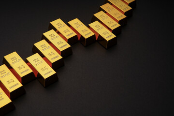 Gold bars next to each other on a black background. Shiny precious metal for investment or as a reserve. Place for text.