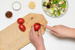 © Daria Vorontsova - woman chef is cooking, making diet homemade caesar salad, step by step instruction. Step 3 - cutting tomatoes, adding them to the bowl
