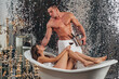 Sexy muscular valentine man pleasure. Luxury lifestyle. Sexy couple in bath. Rich young woman with girl in bathroom. Strong muscular male in bathroom. Glamour.